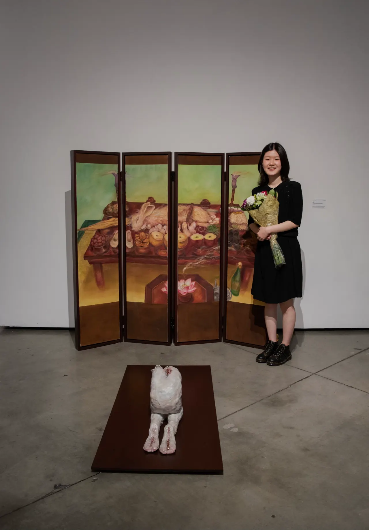 Yoon Lee with her folding-screen painting and ceramic sculpture at an exhibition